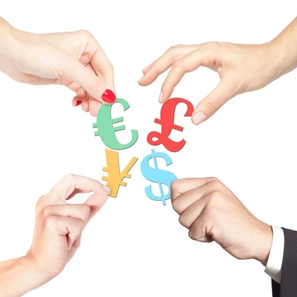 Hands holding major global currency symbols